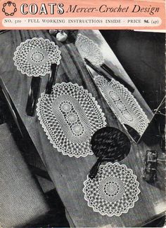 an old book with crochet doily on it and other items sitting on the table