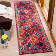 a bright pink rug is on the floor next to a chair and vase with yellow flowers