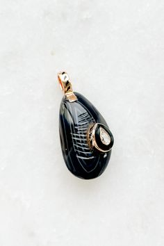 Agate Mussel with Diamond Charm from Dezso by Sara Beltran Hand-carved line agate in the shape of a mussel shell Raised center diamond set in black enamel and 18K gold 18k gold bale with black fin enamel Charm measures approximately 1" length (including bale) x 0.3" width Hand-carved in Jaipur, India Mussel Shell, Diamond Charm, Enamel Charms, Black Enamel, Agate, Hand Carved, 18k Gold, Shells, Carving