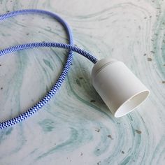 a blue and white cord connected to a light fixture on a marble counter top,