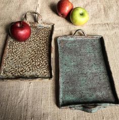 two trays with apples sitting on top of a table