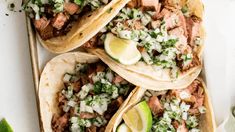 three tacos filled with meat, onions and cilantro