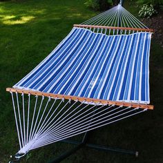 a blue and white striped hammock sitting in the grass