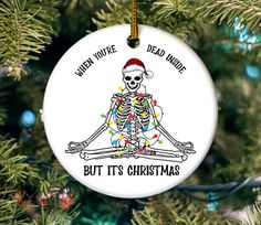 a christmas ornament with a skeleton on it that says, even you're dead now but it's christmas