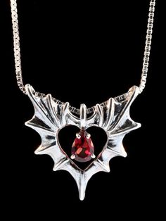 Two bat or dragon wings meet to form one heart. Open your heart to Love. The Phantom Heart Pendant is cast in sterling silver, is 1 1/16” wide by 1 1/8” tall and carefully detailed both front and back. A brilliant pear-shaped 5mm x 7mm gemstone is set in the open center. Treat yourself or gift that special someone with this wickedly wonderful token of love.Please select your desired gemstone in the dropdown options menu. You may choose between a Blue Topaz, Citrine, Amethyst, Peridot, Mozambique Gothic Heart Shaped Necklace For Gifts, Gothic Heart-shaped Anniversary Jewelry, Gothic Winged Jewelry For Gifts, Fantasy Winged Jewelry Gift, Gothic Heart Shaped Chain Necklace, Gothic Heart Pendant Chain Jewelry, Gothic Winged Jewelry Gift, Silver Winged Fantasy Jewelry, Gothic Sterling Silver Heart Pendant Jewelry