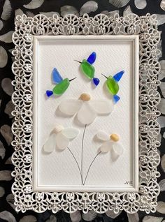 a white frame with some glass flowers on it