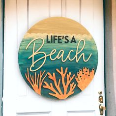 a wooden sign that says life's a beach with corals and seaweed