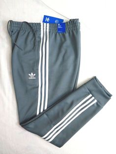 Fresh Stock Brand New with Tags ADIDAS ORIGINALS Men's SST Track Pants Size XL (X-Large) in Blue Oxide Color Waist Measurement Unstretched: 36" (91cm) Inseam: 31" (79cm) Outseam: 39" (99cm) Leg Opening: 6" (15cm) Front Rise: 11" (28cm) - Slim fit - - Elastic waist with drawcord - - Heavyweight fabric - - Machine wash - - Front zip pockets - - Ribbed cuffs - - Tapered legs - - Adidas Originals Trefoil logo at left thigh - From Smoke Free Environment in Stock! Ship Immediately from California! Pic Adidas Originals Mens, Pants Blue, Track Pants, Adidas Originals, Zip Pockets, Sweatpants, Track, Slim Fit, Adidas