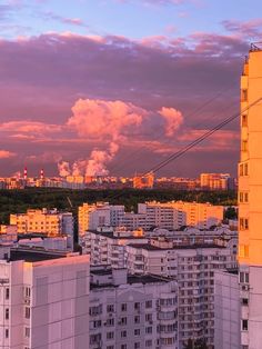 the city is full of tall buildings and smokestacks in the sky at sunset