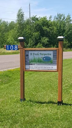 a sign in the grass that says a fresh perspective with trees and bushes behind it