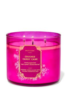 a pink candle that is sitting in front of a white background with flowers on it