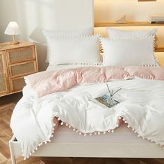 a white bed with pink and white pillows