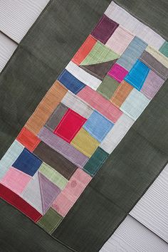 a patchwork quilt hanging on the side of a house's sidings,