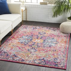 a living room area with white couches and colorful rugs