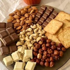 an assortment of nuts, crackers, and bars on a plate