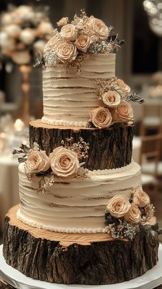 a three tiered wedding cake with flowers on it sitting on top of a table