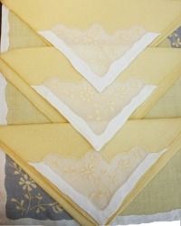 four folded yellow and white napkins on top of each other