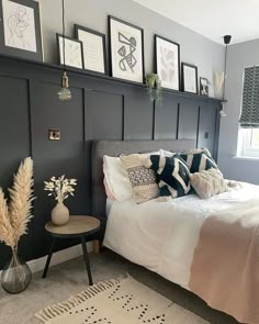 a bedroom with gray walls and pictures on the wall