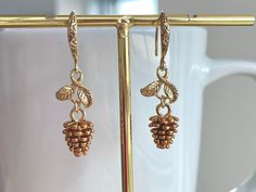 These dainty pinecone earrings are made of the followings: Pinecone: gold plated over brass with brown enamel (Size: 9 (includes loop) x 8mm) Leaf / Earring Hooks: gold plated over brass Drop length: 29mm approx. 【BEFORE PURCHASE, PLEASE NOTE THE FOLLOWINGS】 ☆ VAT, GST and any other taxes from your country are NOT included in the listing price. Buyers are responsible for any aforesaid taxes and must be paid upon delivery. ☆ Buyers are responsible for any customs and import taxes that may apply. Pinecone Earrings, Pine Cone Jewelry, Leaf Earring, Winter Earrings, Earring Hooks, Pine Cone, Gold Plated Earrings, Leaf Earrings, Pine Cones