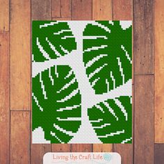 a cross - stitch pattern of green leaves on a wooden background with the words living the craft life