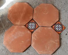 four orange and blue tiles sitting on top of a cement floor