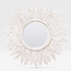 a round mirror that is made out of glass and has spikes on the top of it