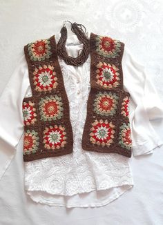 a white shirt with a brown and red vest on it