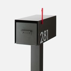 a black mailbox with a red stick sticking out of it's side and the number 1380