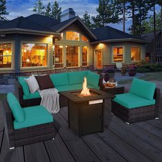 a fire pit sitting on top of a wooden deck next to a patio furniture set