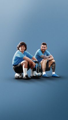 two men sitting on the ground with their skateboards in front of them, both wearing blue shirts and black shorts