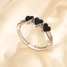 This black heart movable ring in sterling silver is a captivating symbol of love and devotion. The ring itself is sleek and elegant, crafted from pure silver that shines with a timeless brilliance. The unique point lies in its three removable black hearts. As you wear this ring, the hearts glide along the track, reminding you of the journey you've shared with your loved one. They represent the ups and downs, the laughter and tears, and all the moments that have brought you closer together.Carat Track Black, Black Hearts, Ups And Downs, Black Heart, Love Symbols, Ring Sterling Silver, Pure Silver, Cocktail Rings, Sterling Ring