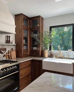 a kitchen with marble counter tops and wooden cabinets, along with a white stove top oven