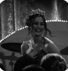 a woman wearing a tiara and smiling at someone