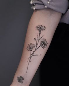 a woman's arm with a flower tattoo on it