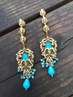 TURQUOISE CHANDELIER EARRINGS You are looking at beautiful hand crafted Turquoise Blue and gold Moon shaped chandelier earrings. It took us 3 months to create the look and translate it into this design. ** A one of a kind piece inspired by the Royals fused with the Victorian styling. ** A very rare find ** 18 K Gold plated . ** Traditional Indian Jewelry. **Length- 4 inches ** Lightweight earrings ** All stones used are lab created These earrings will be shipped with delivery confirmation Also a Blue Chandbali Chandelier Earrings For Wedding, Bohemian Chandelier Earrings For Weddings And Festivals, Bohemian Drop Earrings For Weddings, Bohemian Blue Danglers For Wedding, Gold Chandelier Earrings With Peacock Design For Wedding, Bohemian Chandbali Chandelier Earrings For Wedding, Gold Bohemian Danglers For Wedding, Blue Bohemian Danglers For Wedding, Gold Traditional Chandelier Earrings With Intricate Design