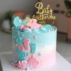 a blue and pink baby shower cake on a table