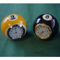 two pool balls with numbers on them and a clock