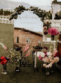 a wedding sign and flowers on the grass