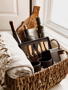 a wicker basket filled with bottles and utensils on top of a white counter