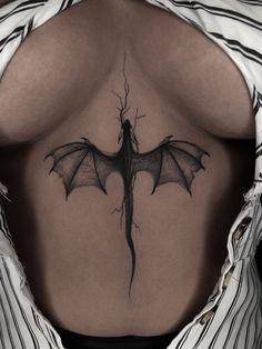 a woman's back with a dragon tattoo on her lower back and the upper part of her stomach