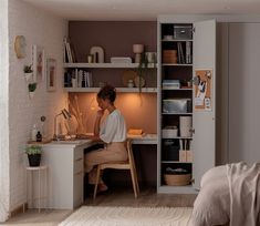 a woman sitting at a desk in front of a book shelf