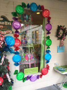 a window display with balloons, candy canes and other decorations on the windowsill