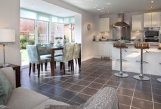 a kitchen and dining room with tile flooring in the middle of an open living area