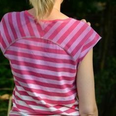 a woman wearing a pink and white striped shirt with her back turned to the camera