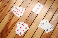 four playing cards laid out on top of a wooden table