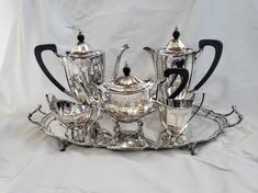 a silver tea and coffee set sitting on top of a tray