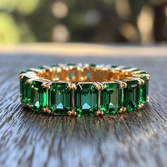 an emerald colored ring is sitting on a table