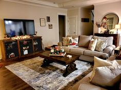 a living room filled with furniture and a flat screen tv on top of a wooden table