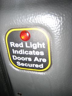 a red light indicates indicators for doors are secured on the inside of a vehicle's door