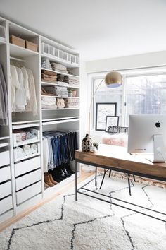 a dog is laying on the floor in front of a computer desk and closets